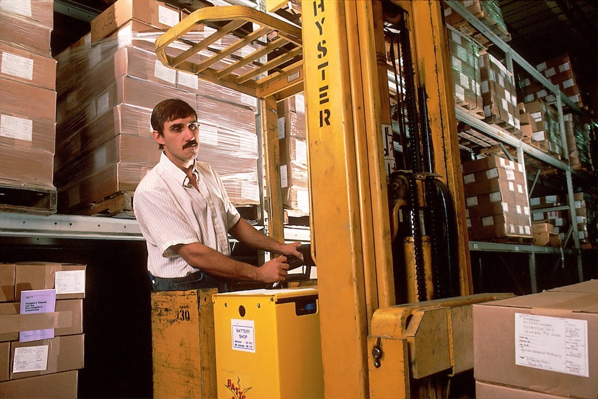 Forklift operator in industrial warehouse